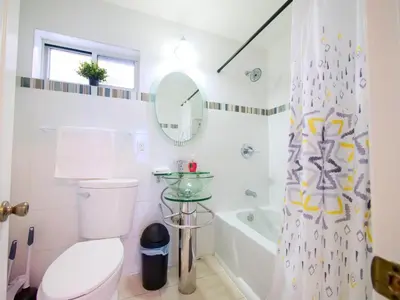 a white bathroom with a toilet and a shower curtain at 2BED Cozy unit near NYC attractions in Jersey City