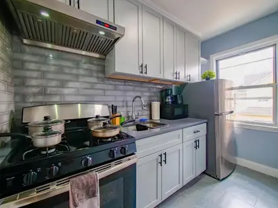 a kitchen with a stove with pots and pans on it at 2BED Cozy unit near NYC attractions in Jersey City