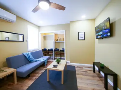 a living room with a blue couch and a tv at 2BED Cozy unit near NYC attractions in Jersey City