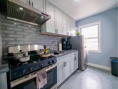 a kitchen with a stove with pots and pans on it at 2BED Cozy unit near NYC attractions in Jersey City