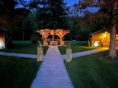 a backyard walkway with a pergola at night at Antrim Streamside in Livingston Manor