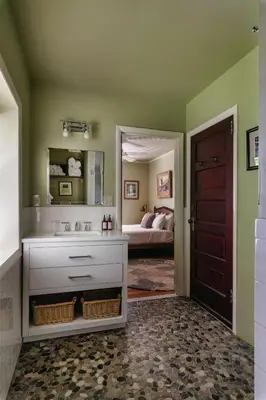 a bathroom with a sink and a bedroom with a bed at Antrim Streamside in Livingston Manor