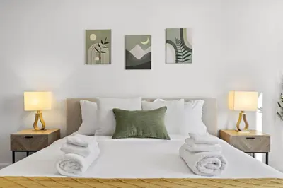 a bedroom with a white bed with towels on it at Free Parking 1BR Spacious BoHo 30Min to NYC in Bayonne