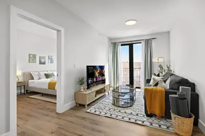 a bedroom with a bed and a living room with a couch at Free Parking 1BR Spacious BoHo 30Min to NYC in Bayonne