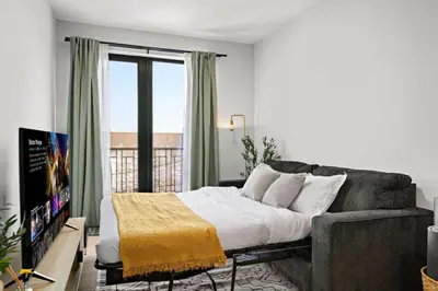 a living room with a couch and a tv at Free Parking 1BR Spacious BoHo 30Min to NYC in Bayonne