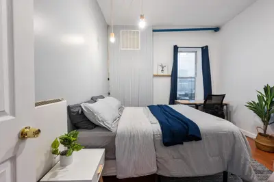 a bedroom with a bed and a desk and a window at 4 Bedroom 1 Bathroom Hudson Yard in New York