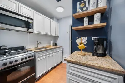 a kitchen with white cabinets and a stove at 4 Bedroom 1 Bathroom Hudson Yard in New York