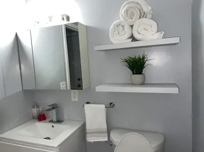 a bathroom with a sink and a toilet and a mirror at Comfy Fairmount in Newark
