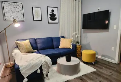a living room with a blue couch and a table at Comfy Fairmount in Newark