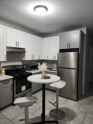 a kitchen with a table and a stainless steel refrigerator at Comfy Fairmount in Newark