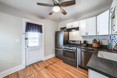 a kitchen with stainless steel appliances and a ceiling fan at 1 Mi to Dtwn Binghamton Apt with Covered Balcony! in Binghamton