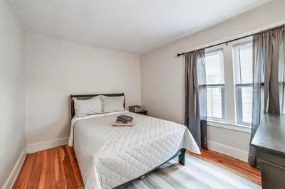 a bedroom with a bed and a large window at 1 Mi to Dtwn Binghamton Apt with Covered Balcony! in Binghamton