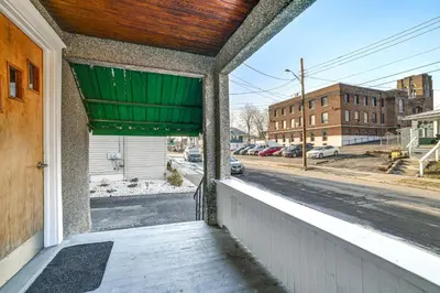an empty porch with a green curtain and a street at 1 Mi to Dtwn Binghamton Apt with Covered Balcony! in Binghamton