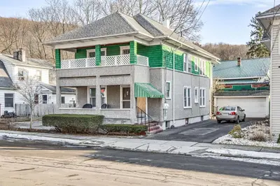 a house with a green balcony on a street at 1 Mi to Dtwn Binghamton Apt with Covered Balcony! in Binghamton