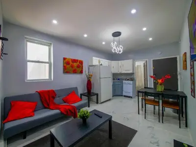 a living room with a couch and a kitchen at Sleek one-bedroom abode near NYC in Jersey City