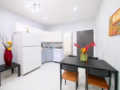 a kitchen with a black table and a white refrigerator at Sleek one-bedroom abode near NYC in Jersey City