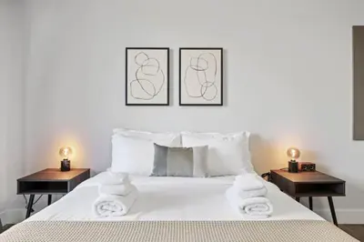 a bedroom with a white bed with towels on it at Modern Retreat Free Parking 30Min NYC in Bayonne