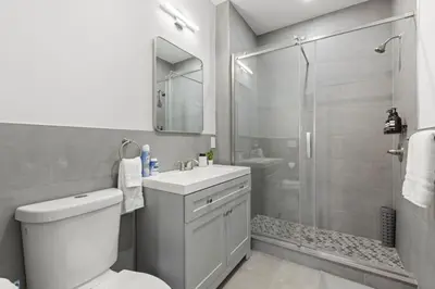 a bathroom with a shower and a toilet and a sink at Modern Retreat Free Parking 30Min NYC in Bayonne