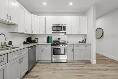 a kitchen with white cabinets and stainless steel appliances at Modern Retreat Free Parking 30Min NYC in Bayonne