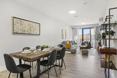 a dining room and living room with a table and chairs at Modern Retreat Free Parking 30Min NYC in Bayonne