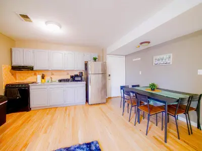 a kitchen with a table and chairs and a refrigerator at Deluxe 2-Bedroom Apt minutes from NYC in Jersey City