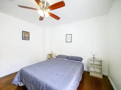 a bedroom with a ceiling fan and a blue bed at Impressive 3bed 2bath apt close to NYC in Jersey City