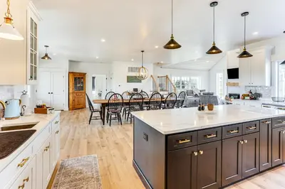 a kitchen with white cabinets and a dining room with a table at Walk to the Amish Village Spacious Ronks Getaway! in Ronks
