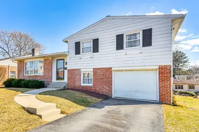 a brick house with a white garage at 3 Mi to Berkshire Mall Suburban Stay with Yard! in Sinking Spring