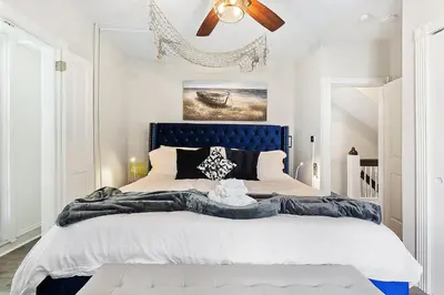 a bedroom with a large bed with a blue headboard at Main Line Manor 3BR with King Beds & Patio & Backyard in Bryn Mawr
