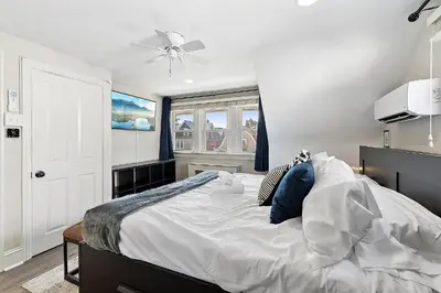 a bedroom with a large bed with blue pillows at Main Line Manor 3BR with King Beds & Patio & Backyard in Bryn Mawr
