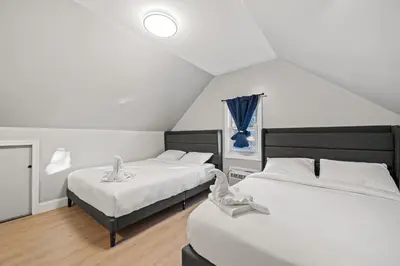 a bedroom with two beds with white sheets at Spacious Luxe Stay Sleeps 16 20 Min to NYC in Bayonne