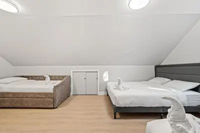 a bedroom with two beds and a couch at Spacious Luxe Stay Sleeps 16 20 Min to NYC in Bayonne