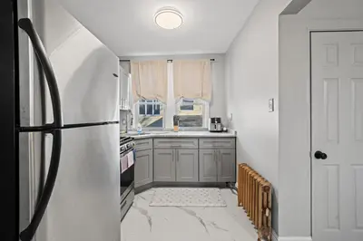 a kitchen with a refrigerator and a window at Spacious Luxe Stay Sleeps 16 20 Min to NYC in Bayonne