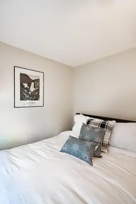 a white bed with two pillows on top of it at Lovely 3BR Homewith free parking-WALK to WP Gate in Highland Falls