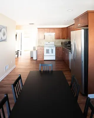 a kitchen with a black table and a refrigerator at Lovely 3BR Homewith free parking-WALK to WP Gate in Highland Falls