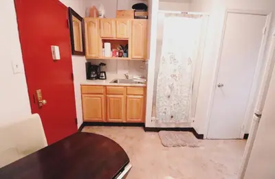 a small kitchen with wooden cabinets and a sink at Quirky & Cozy Loft SoHo Little Italy - Sleeps 4 in New York