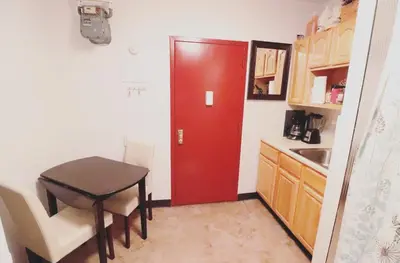 a small kitchen with a red door and a table at Quirky & Cozy Loft SoHo Little Italy - Sleeps 4 in New York