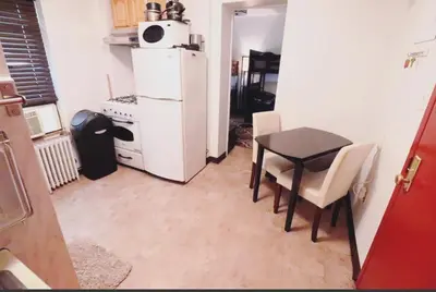 a small kitchen with a table and a white refrigerator at Quirky & Cozy Loft SoHo Little Italy - Sleeps 4 in New York