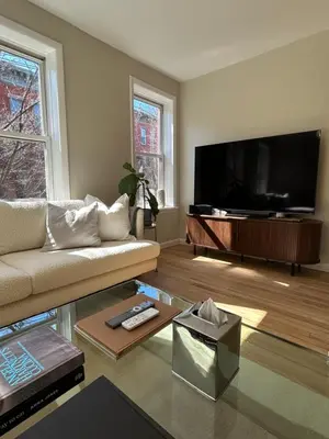 a living room with a couch and a flat screen tv at NEW! Historic Townhouse-14 min to WTC in Jersey City