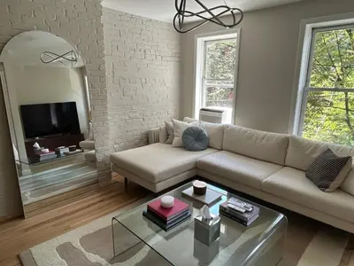 a living room with a couch and a mirror at NEW! Historic Townhouse-14 min to WTC in Jersey City