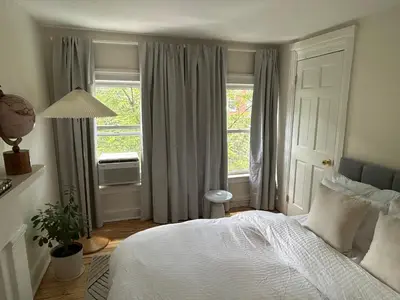 a bedroom with a white bed and a window at NEW! Historic Townhouse-14 min to WTC in Jersey City