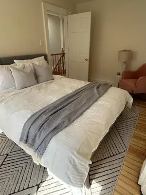 a large white bed in a bedroom with a rug at NEW! Historic Townhouse-14 min to WTC in Jersey City
