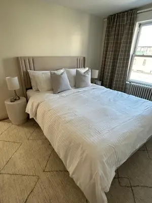 a large white bed in a bedroom with a window at NEW! Historic Townhouse-14 min to WTC in Jersey City