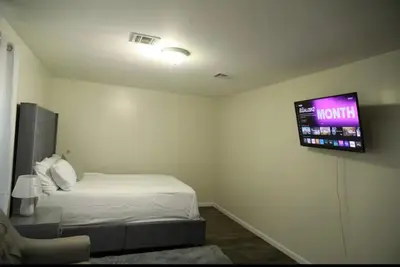 a room with a bed and a tv on the wall at Elegant 3BR Home - Near the Prudential Center in Newark