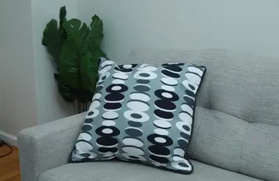 a pillow sitting on a couch in a living room at Elegant 3BR Home - Near the Prudential Center in Newark