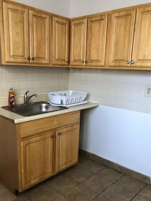 a kitchen with wooden cabinets and a sink at Private one-bedroom and one-bathroom apartment with private street entrance in convenient area, MetLife Stadium FIFA World Cup 35 minutes away in Perth Amboy