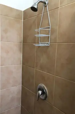 a shower with a shower head on a tiled wall at Private one-bedroom and one-bathroom apartment with private street entrance in convenient area, MetLife Stadium FIFA World Cup 35 minutes away in Perth Amboy