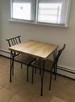 a wooden table with two chairs and two windows at Private one-bedroom and one-bathroom apartment with private street entrance in convenient area, MetLife Stadium FIFA World Cup 35 minutes away in Perth Amboy