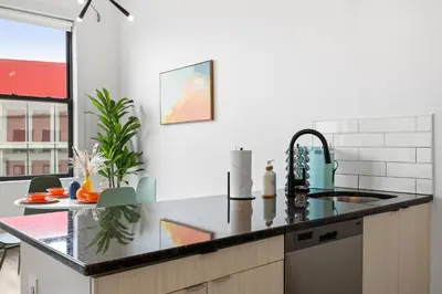 a kitchen with a sink and a counter top at Lofts at Kearny - Rustic Chic 1-3BR Lofts with Quick NYC Access & On-Site Gym in Kearny