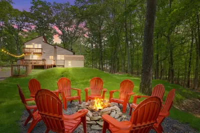 a group of chairs around a fire pit in a yard at Secluded Cabin, Jacuzzi, Pool Table, King Bed & Fire Pit in Bushkill